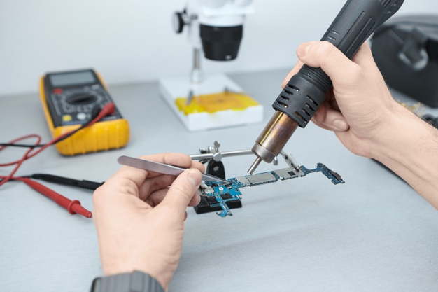 repairman-soldering-components-motherboard-while-fixing-damaged-smart-phone-using-tweezers-iron_343059-504