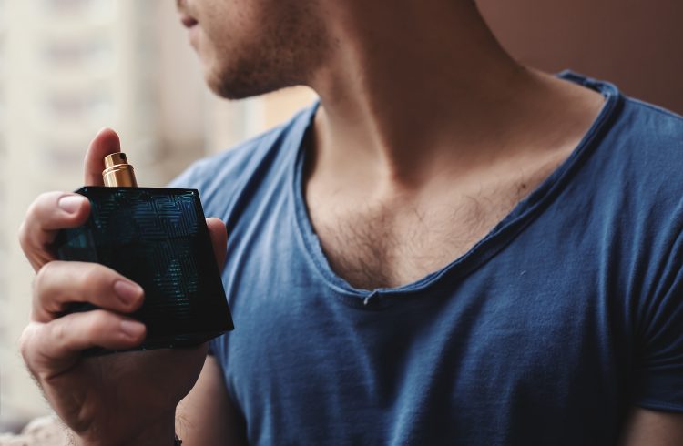 young man applying perfume