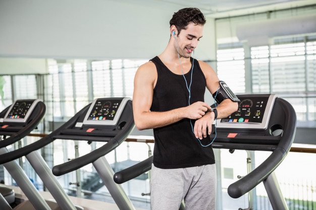 smiling-man-treadmill-using-smart-watch-gym