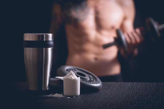 Whey protein shaker and dumbbells