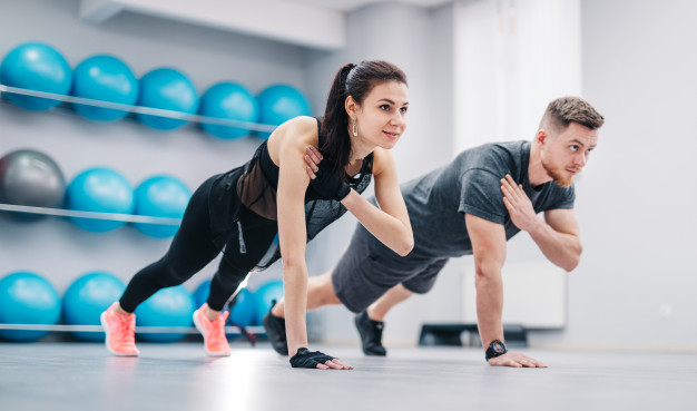 young-couple-doing-push-ups-from-floor-one-hand-together