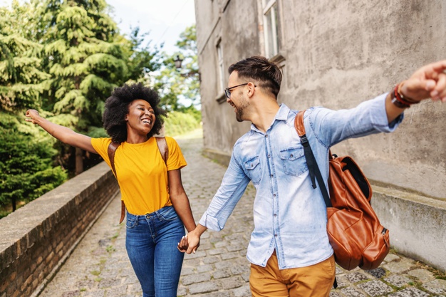 Young cute multicultural couple taking a walk in an old part of the town