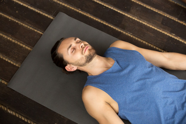 Young sporty man lying in dead body exercise