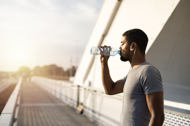 attractive-athlete-holding-bottle-water-drinking-before-training