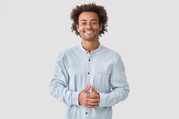 male with positive smile, shows white teeth, keeps hands on stomach