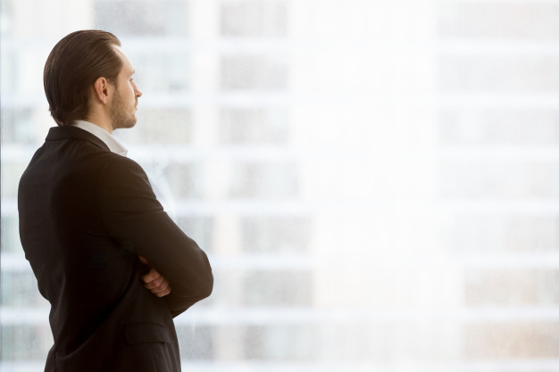 businessman-dreamily-looks-window-office