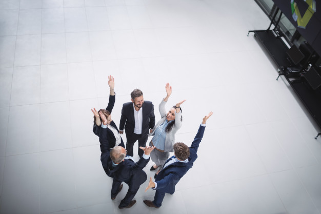 Businesspeople standing with hands raised 