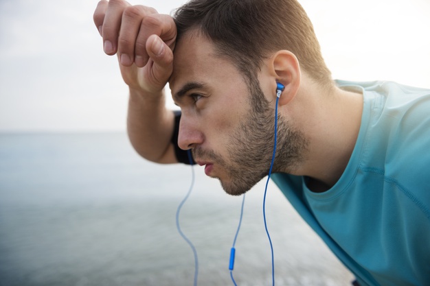 close-up-young-fit-person-jogging-by-sea