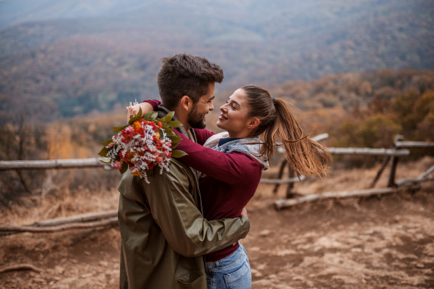 Couple hugging while standing on viewpoint