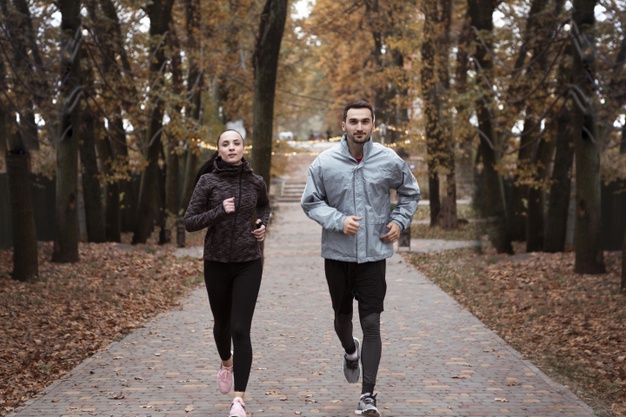 Full shot people running outdoors 