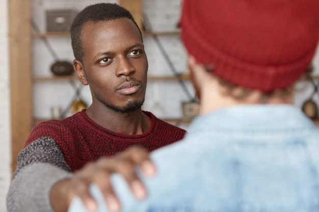 young african american man showing compassion to unrecognizable male