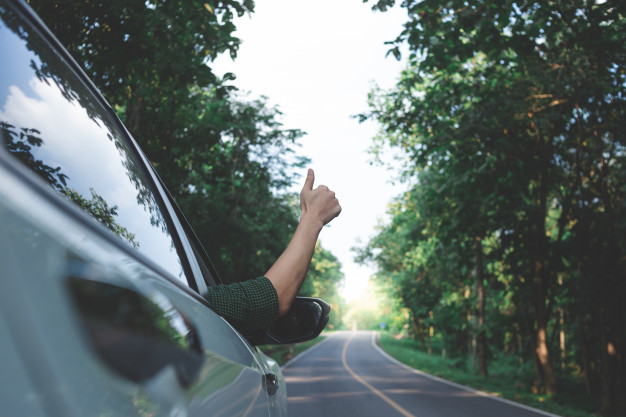 Man driver feeling the wind through his hands while driving in the country side