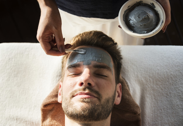 Man getting a mud mask at a spa 