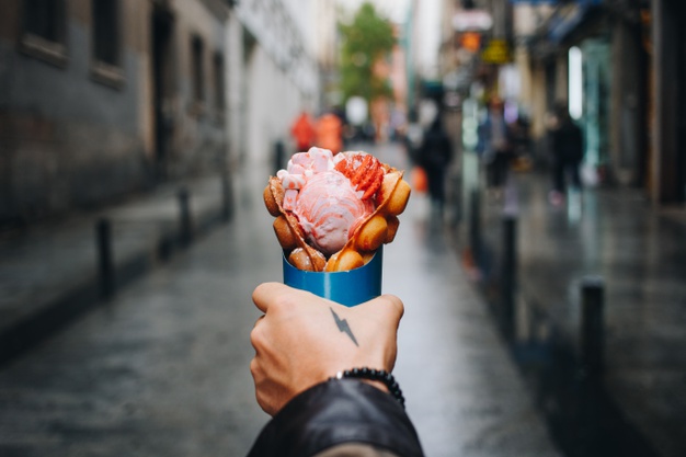 Man holds bubble waffle from street food truck