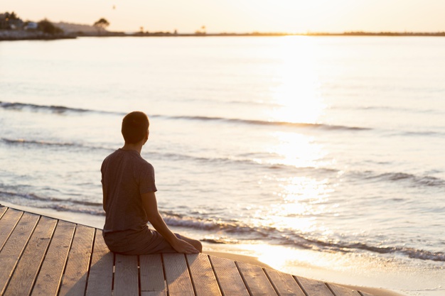 man-meditating-beach