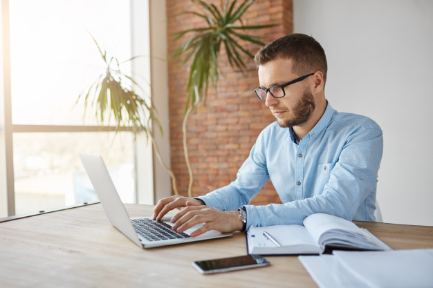 male freelance web designer sitting in co-working space
