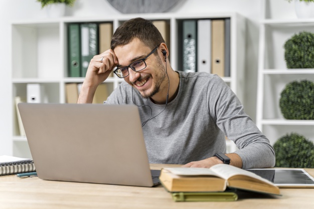 Medium shot smiley guy studying with his laptop
