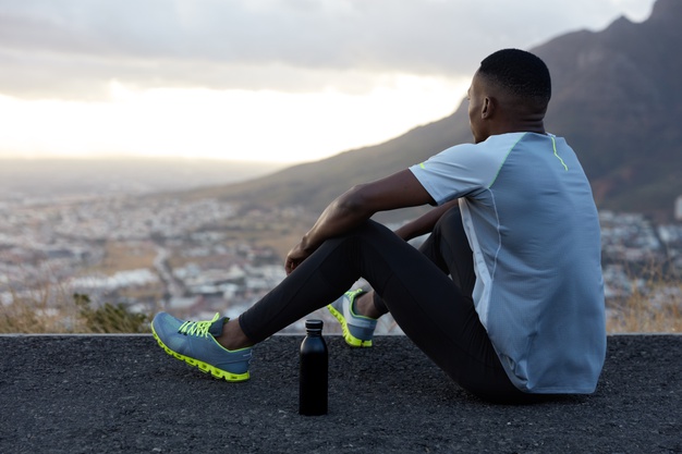 outdoor-view-relaxed-african-american-man-with-dark-healthy-skin-drinks-water