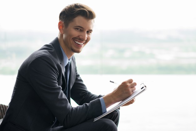 Smiling middle-aged businessman making notes
