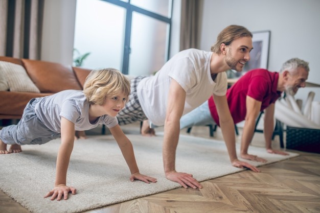 Yoga with son. grey-haired fit man doing yoga together with his son