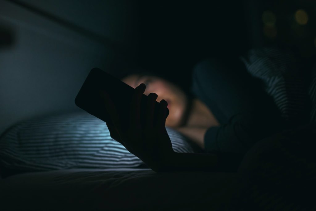 man using smartphone in the dark