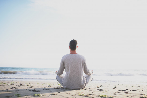 young-man-practice-yoga-beach-sunset