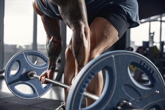 young-muscular-caucasian-athlete-practicing-pull-ups-gym-with-barbell