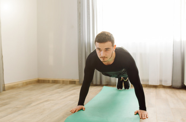 Young man making sport exercises at home
