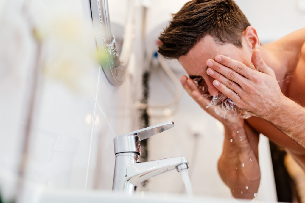 Man washing face with facial cleanser