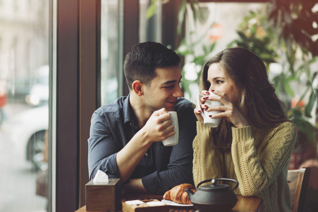 A couple sitting at cafe laughing cheerfully
