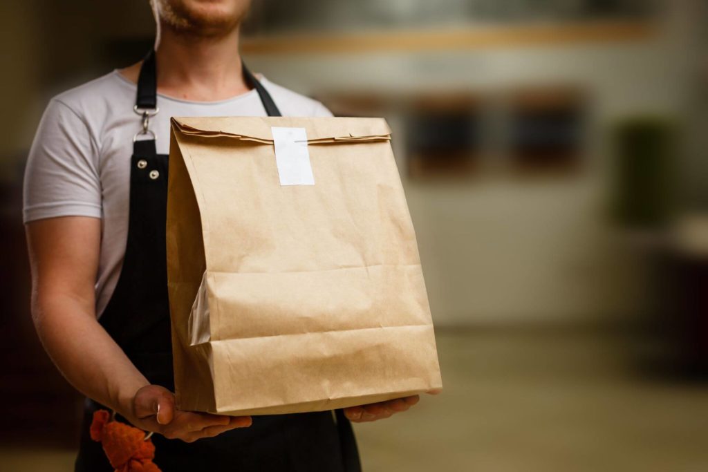 Delivery man holding paper bag