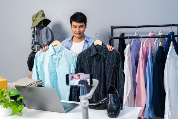 Young Man Selling Shoes And Clothes Online By Laptop Live Streaming