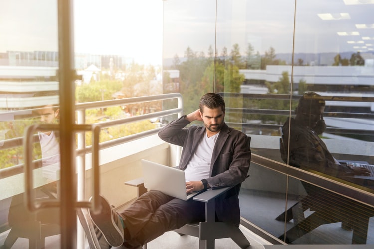 man sitting on gray arm chair