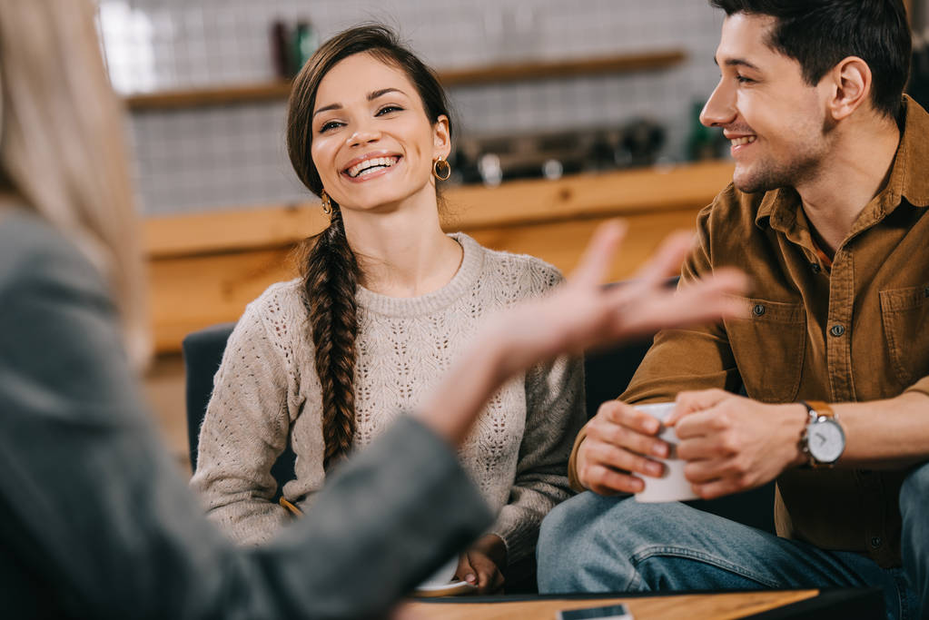 cheerful friends chatting in cafe