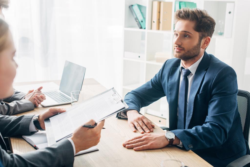 employee looking at recruiter with resume during job