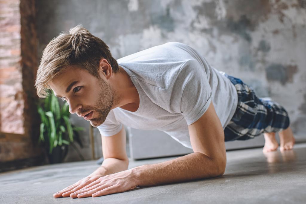 man doing plank during morning time at home