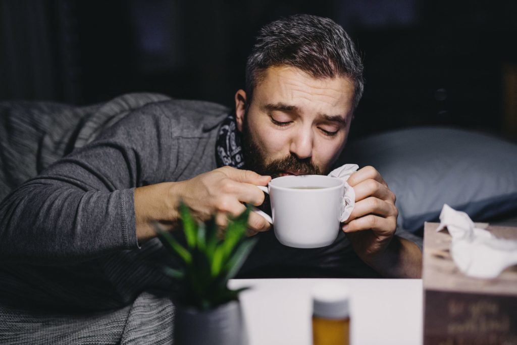 Man on bed drinking coffee