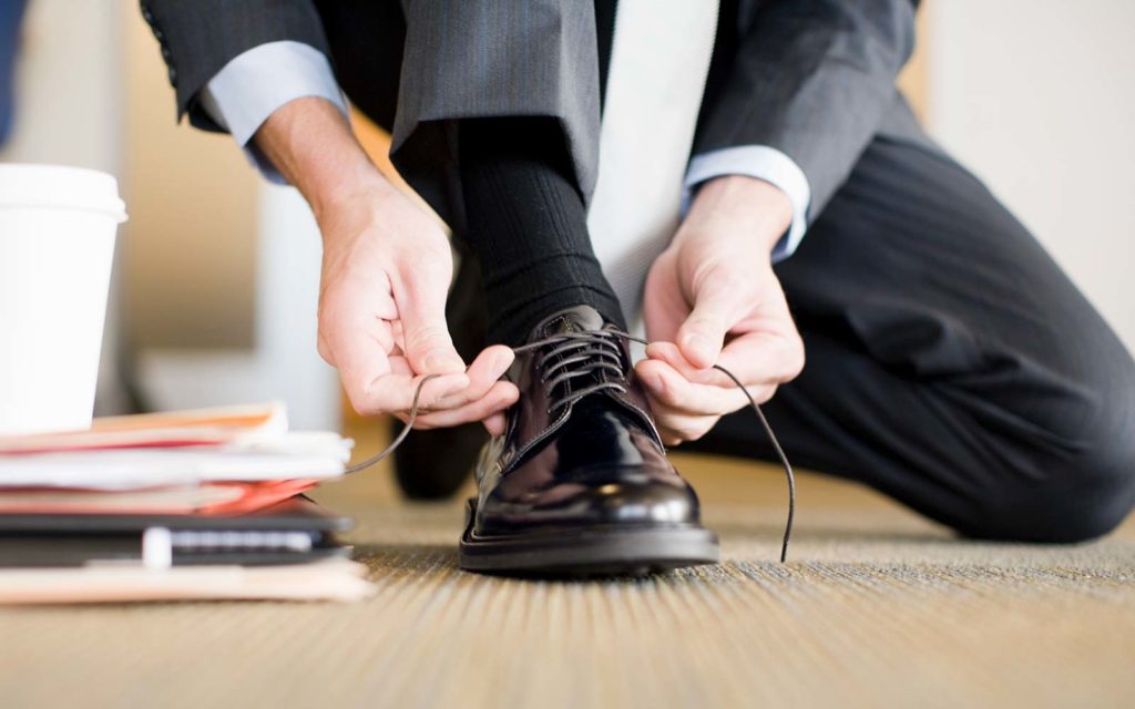 Businessman tying shoe