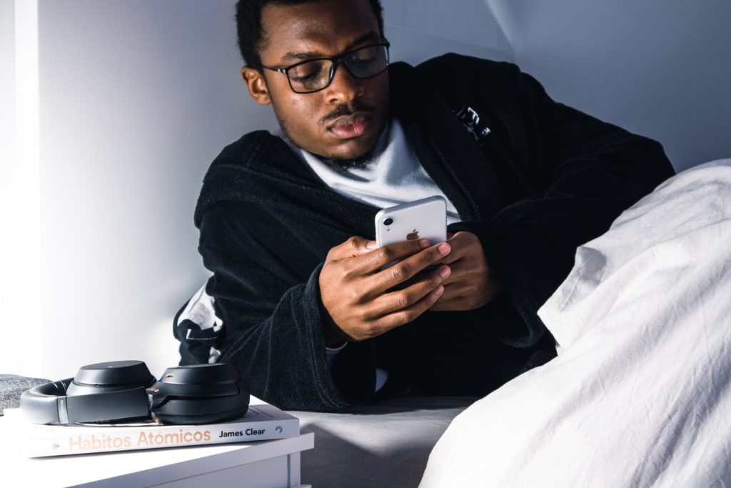 man using smartphone on the bed