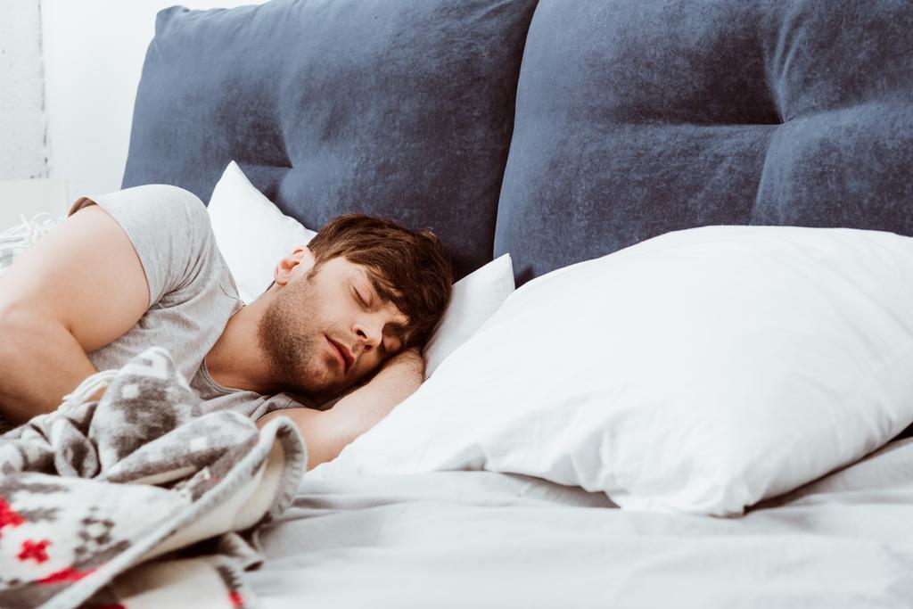  man sleeping in bed at home