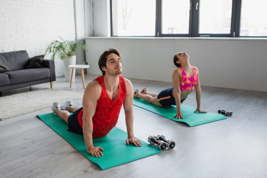 young man and woman practicing yoga