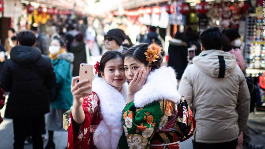 Two women wearing kimonos pose for a selfie around Sensoji temple in the Asakusa district of Tokyo