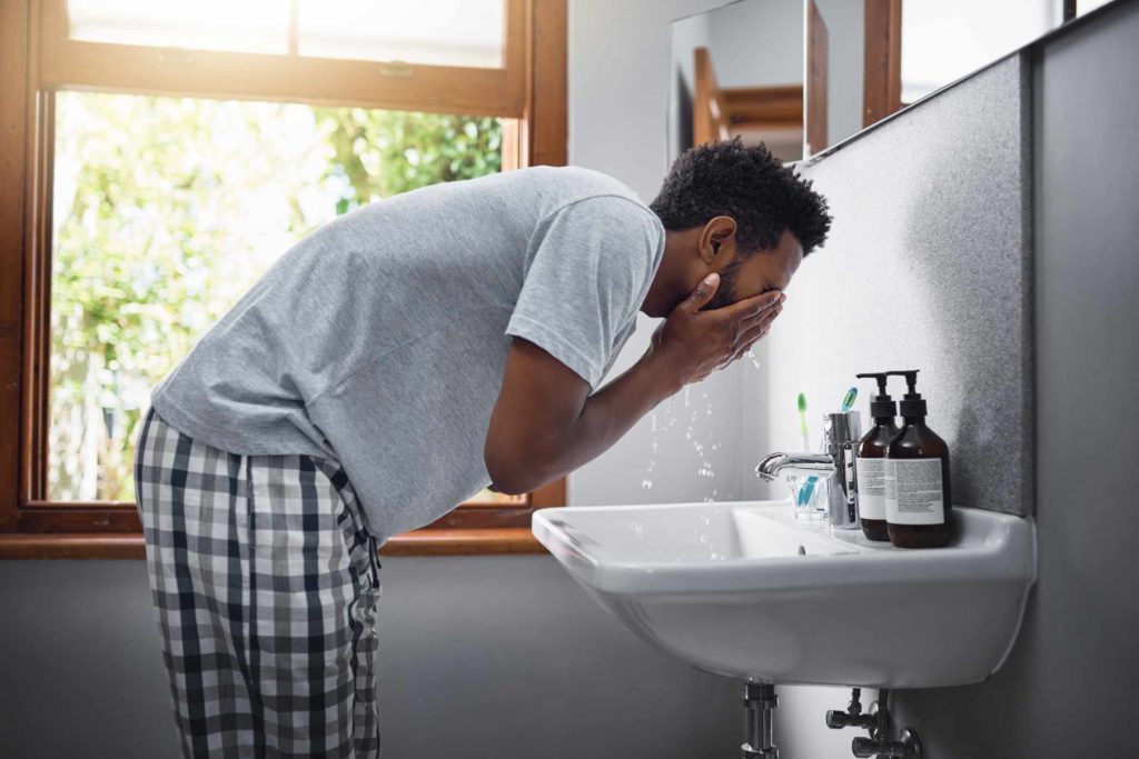 Black Man Washing Face