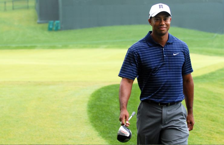Tiger-Woods-smiling-with-golf-iron-in-right-hand