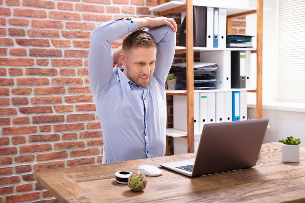 man talking stretching at desk 