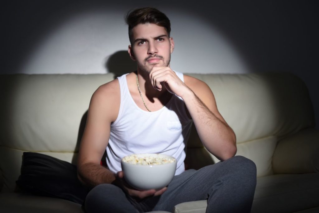 man watching movie on sofa at home