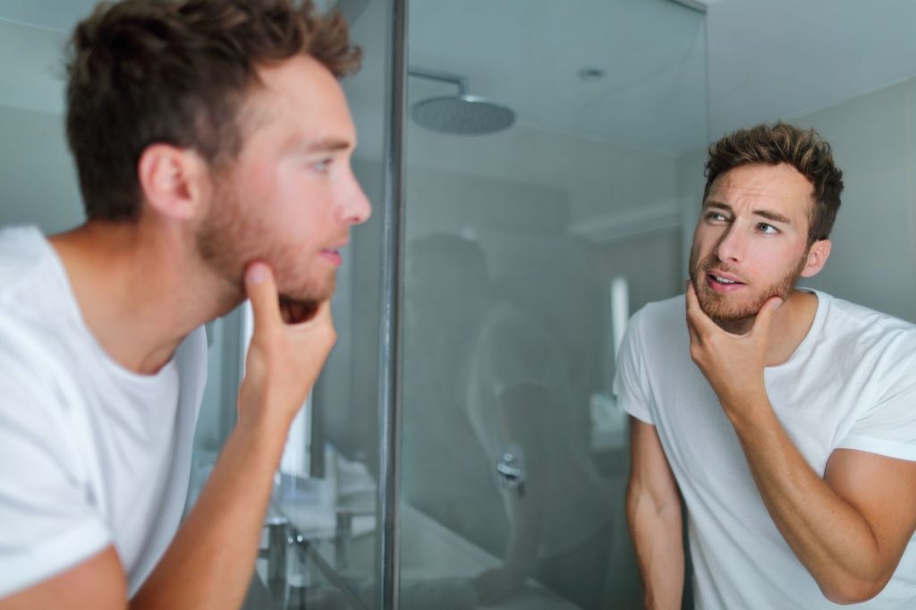 man in Bathroom look at the mirror