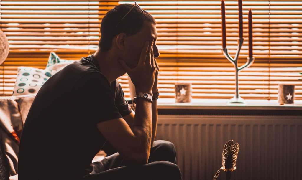 Stressed Young Man sitting on sofa