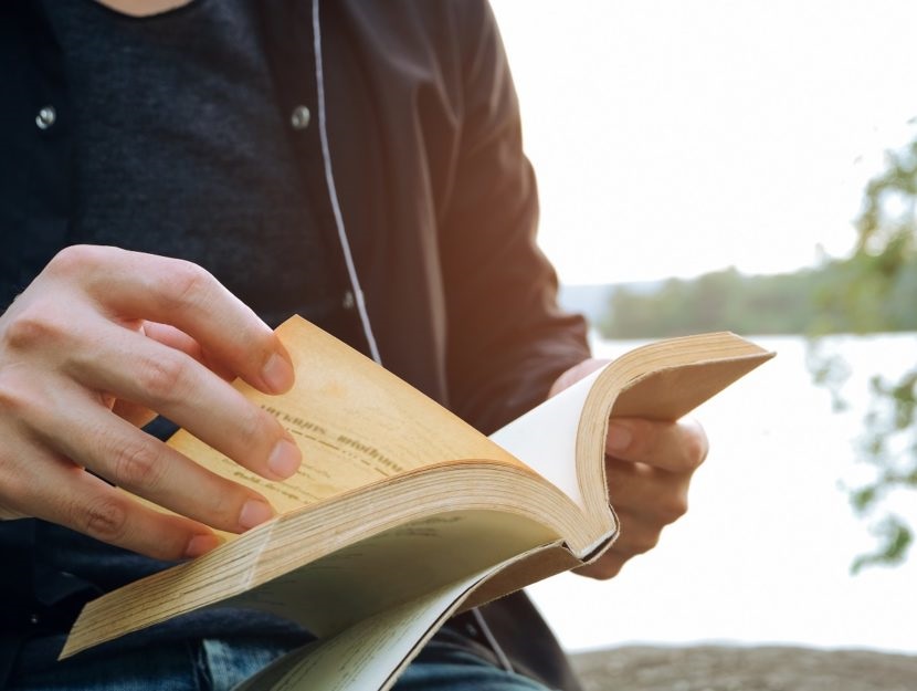Young man opening and reading a book