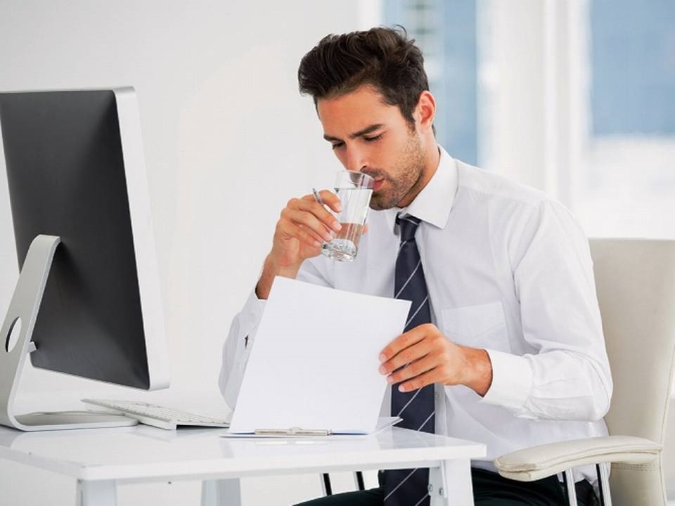  Business sitting in his office,working and drinking water 